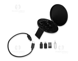 Puck de metal preto brilhante com símbolos de seta, círculos e botões, representando um Kit Cabo USB-C com 3 Adaptadores.