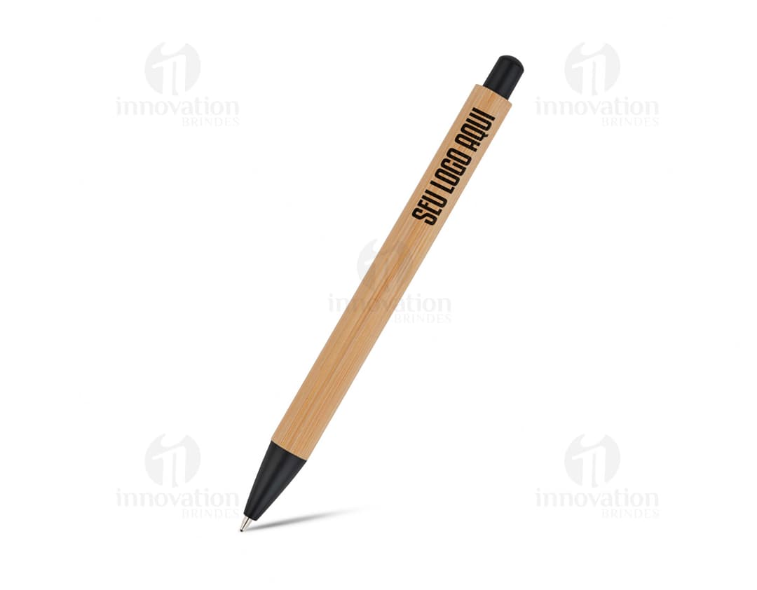 Bamboo ballpoint pen in black with silver details, placed on a white paper and a notebook. The item is positioned closed