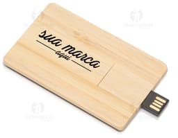 Pen drive em formato de cartão feito de madeira com capacidade de 4GB, sobre uma tábua de cortar, caixa de papelão ao lado