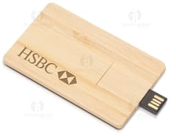 Pen drive em formato de cartão feito de madeira com capacidade de 4GB, sobre uma tábua de cortar, caixa de papelão ao lado