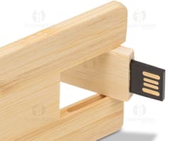 Pen drive em formato de cartão feito de madeira com capacidade de 4GB, sobre uma tábua de cortar, caixa de papelão ao lado