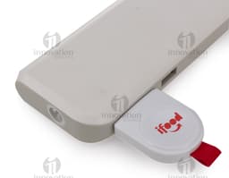 Um carregador por indução iWatch rodeado por equipamentos eletrônicos modernos, como laptops, smartphones, teclados