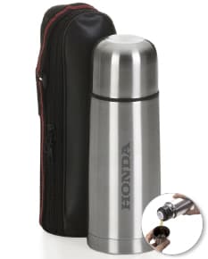 Garrafa térmica de inox de 350ml, brilhante e vazia, com tampa de plástico preta. Está em um campo aberto, refletindo a luz do sol.