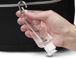 Frasco plástico 55ml con mosquetón siendo sostenido por una mano masculina, en un ambiente de oficina. La imagen muestra