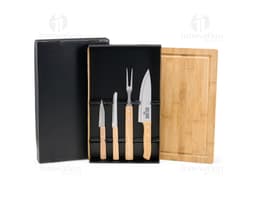 Kit churrasco com 5 peças, incluindo faca, garfo, pegador, espátula e avental com o logo da empresa.