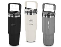 Red thermal water bottle with a screw-on lid and carrying handle. The bottle is on a wooden table, and in the background, a