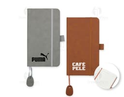Cuaderno de goma con tapa azul y elástico, sobre una mesa de madera.