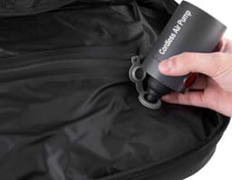 Mochila preta de couro com compartimento a vácuo, carregada por um homem de terno. O homem está sorrindo e parece estar