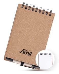 Mini caderno de anotações em papel em branco, com capa marrom de cartão. Acompanha uma caneta e está em cima de um notebook aberto em um escritório, ao lado de uma prancheta e caixa de papelão. A imagem possui um estilo vintage e grunge, com um ar antigo e de memória pessoal.