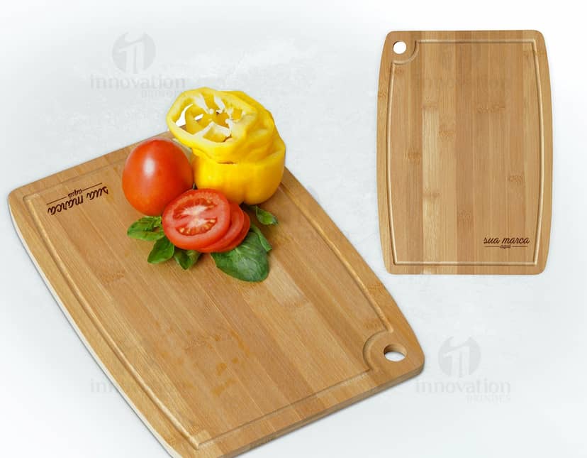 Tábua de corte retangular com gancho e canaleta, ideal para preparar alimentos de forma prática e segura. A tábua parece ser feita em madeira e tem um design moderno.