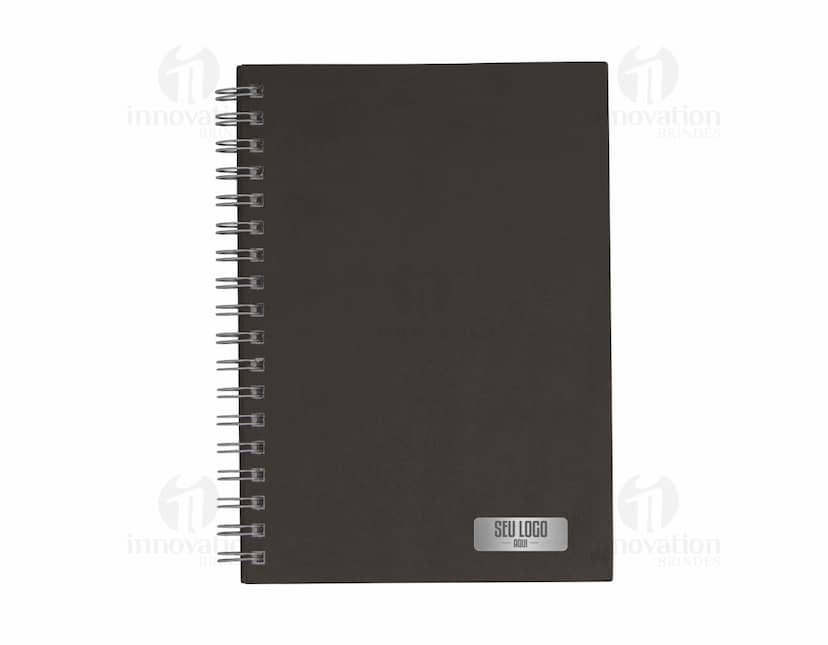 Caderno negócios com capa preta e título impresso em dourado. Páginas pautadas e marcador de página na cor vermelha.