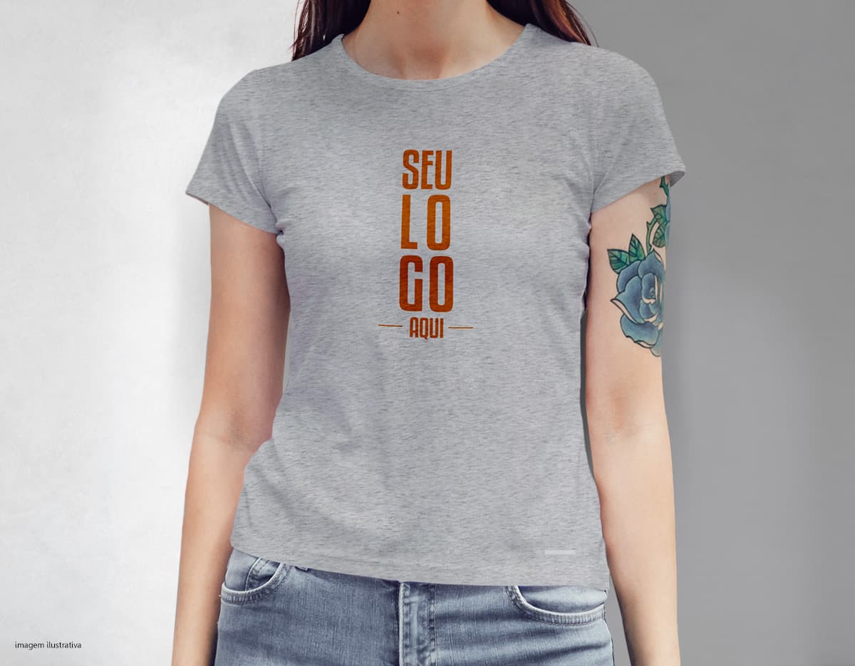Camiseta feminina com uma garota atraente e sorridente, posando de forma casual em um estúdio. O modelo tem cabelos escuros e olhos expressivos, vestindo jeans. Ela transmite confiança e estilo.