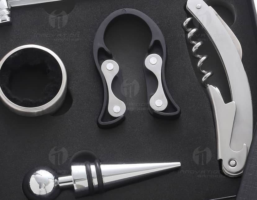 Kit Vinho Completo com 5 Acessórios em fundo branco. O kit inclui saca-rolhas, tampa de garrafa, corta-gotas, anel anti-gotas e termômetro.