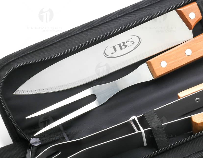 Kit Churrasco 3 Peças com Estojo em fundo branco. O kit inclui faca, garfo e pegador em aço inoxidável, armazenados em estojo de couro marrom.