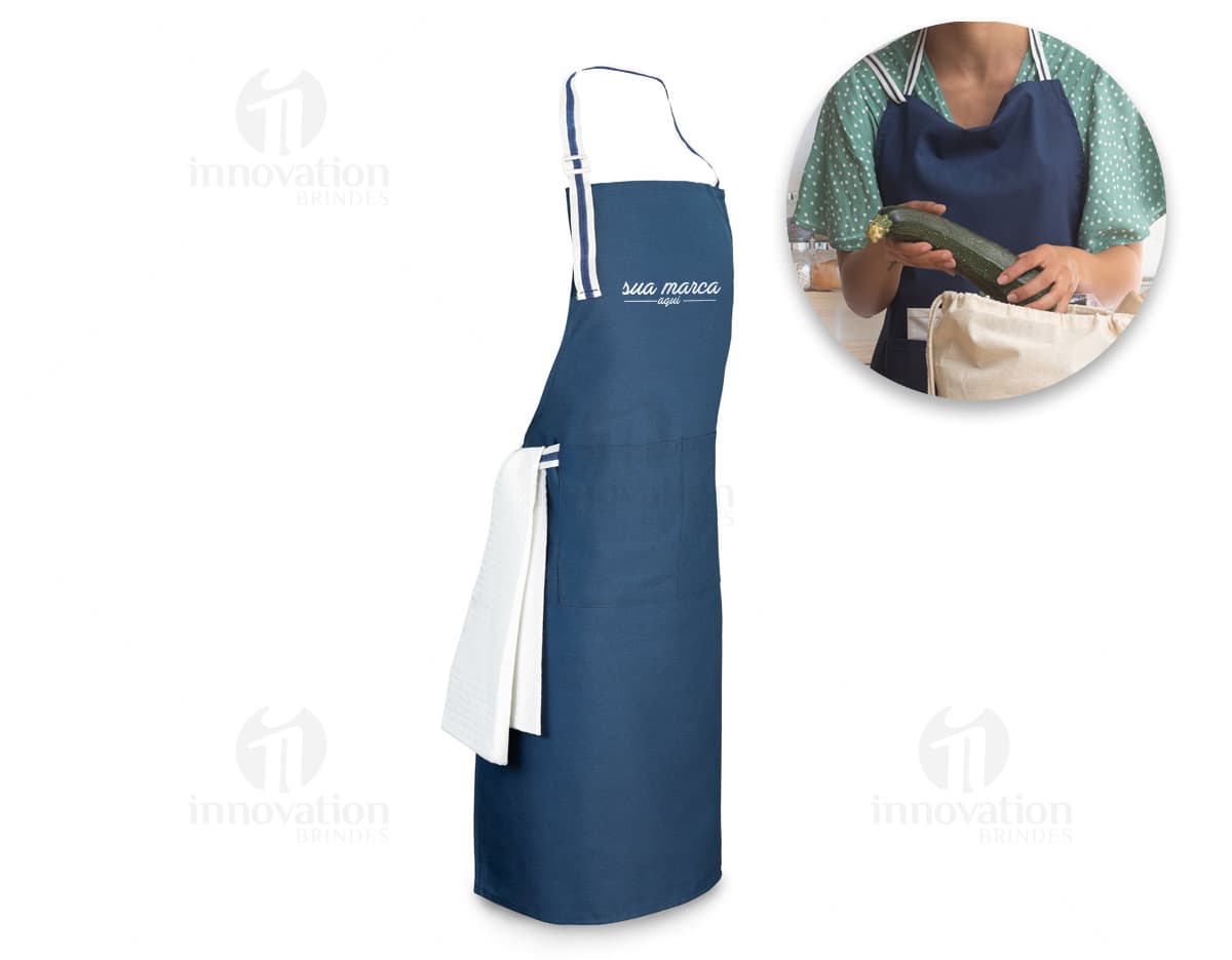 A imagem mostra um avental de cozinha vermelho com detalhes em branco, pendurado em um gancho na parede. O avental tem bolsos na parte da frente e uma alça ajustável no pescoço. A imagem mostra um avental de cozinha vermelho com detalhes em branco, pendurado em um gancho na parede. O avental tem bolsos na parte da frente e uma alça ajustável no pescoço.