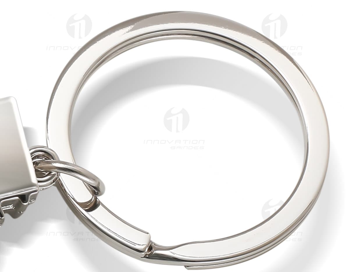 Mosquetão metálico com área gravável em fundo branco. Mosquetão metálico com área gravável em fundo branco.