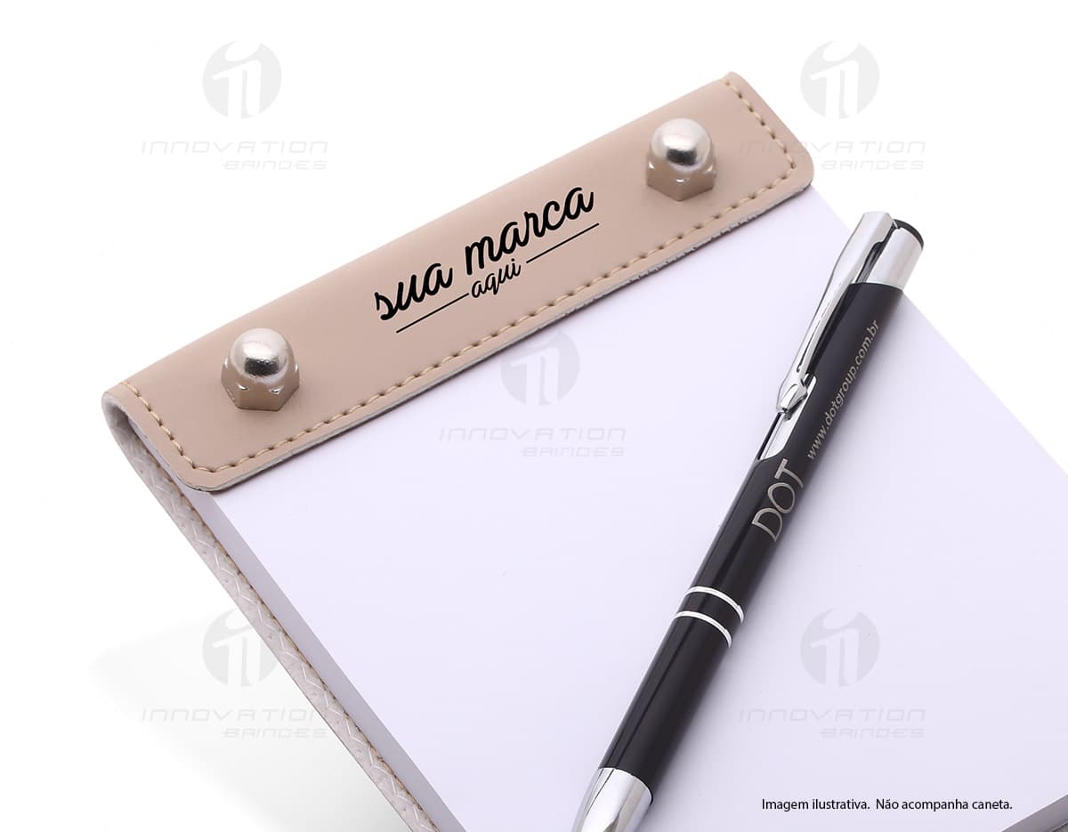 Bloco de anotações preto com capa de couro e elástico para fechamento, sobre uma mesa de madeira. Bloco aberto exibindo várias páginas em branco e uma caneta ao lado. Bloco de anotações preto com capa de couro e elástico para fechamento, sobre uma mesa de madeira. Bloco aberto exibindo várias páginas em branco e uma caneta ao lado.