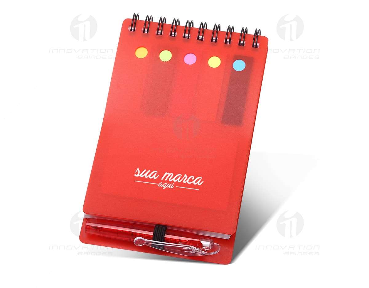 Caderno com dois blocos de escrita em tons de azul e rosa sobre uma mesa de madeira. Caderno com dois blocos de escrita em tons de azul e rosa sobre uma mesa de madeira.