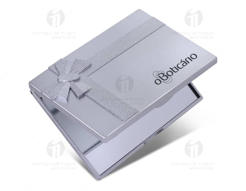 Espelho plástico sem aumento, duplo, apresentado em uma imagem contendo diversos equipamentos eletrônicos e tecnológicos, como scanner, drive, computador, notebook, modem, teclado, tela preta, disco rígido, laptop, telefone, tela prata, monitor, botões, gravador de vídeo, câmera, entre outros. A imagem também inclui objetos de escritório, como papel, livro e caneta, destacando uma cena de trabalho moderna e conectada.