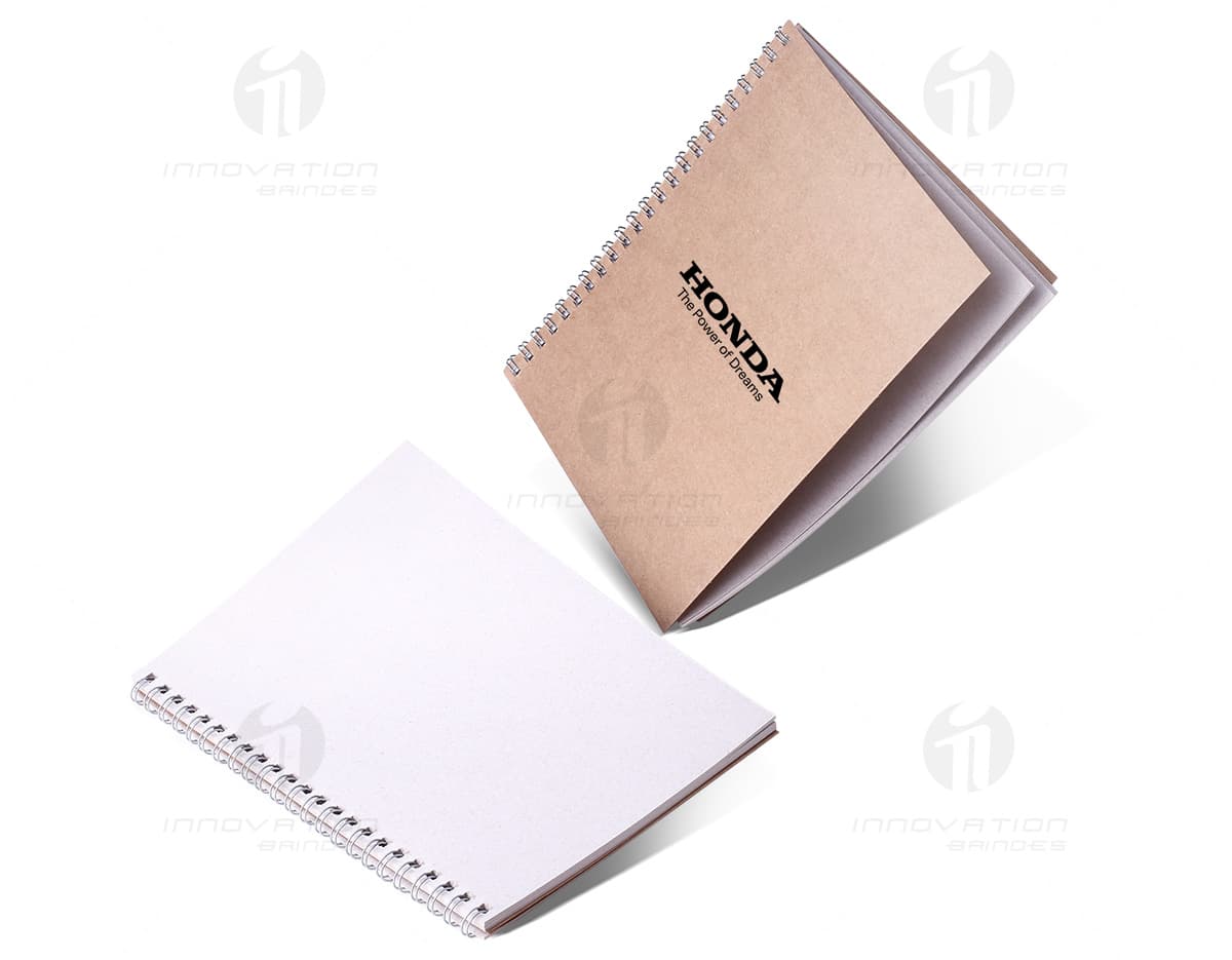 Bloco de notas sustentável com capa de papel reciclado e folhas em tom de verde claro, sobre fundo branco. Bloco de notas sustentável com capa de papel reciclado e folhas em tom de verde claro, sobre fundo branco.