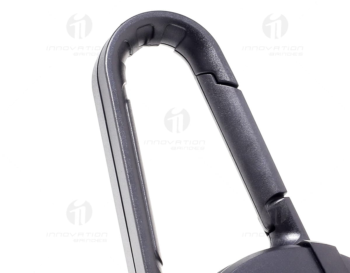 Caixa de som portátil com mosquetão em cor preta, possui botões de controle de volume e design compacto. Caixa de som portátil com mosquetão em cor preta, possui botões de controle de volume e design compacto.