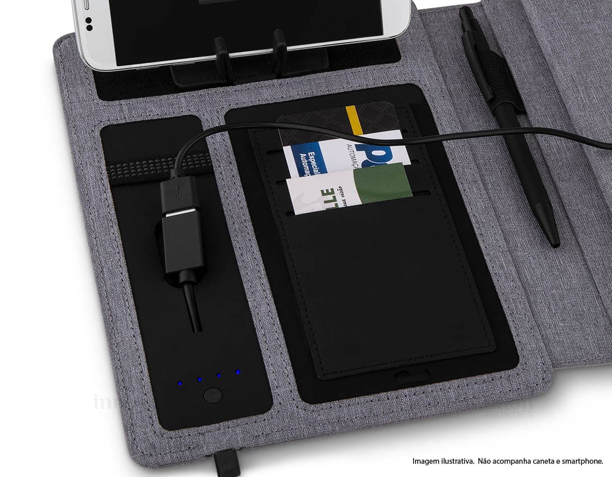 Caderno PU com Powerbank e 64 folhas em fundo branco, destacando a capa de couro sintético preto com Powerbank embutido e diversas folhas brancas com pautas. Caderno PU com Powerbank e 64 folhas em fundo branco, destacando a capa de couro sintético preto com Powerbank embutido e diversas folhas brancas com pautas.