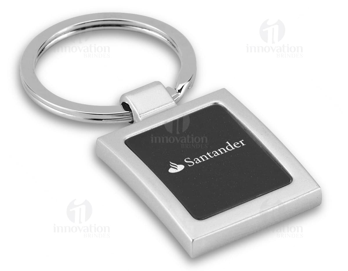 Chaveiro de metal na caixa, objeto prateado com detalhes em relevo e embalado em uma caixa preta. Chaveiro de metal na caixa, objeto prateado com detalhes em relevo e embalado em uma caixa preta.