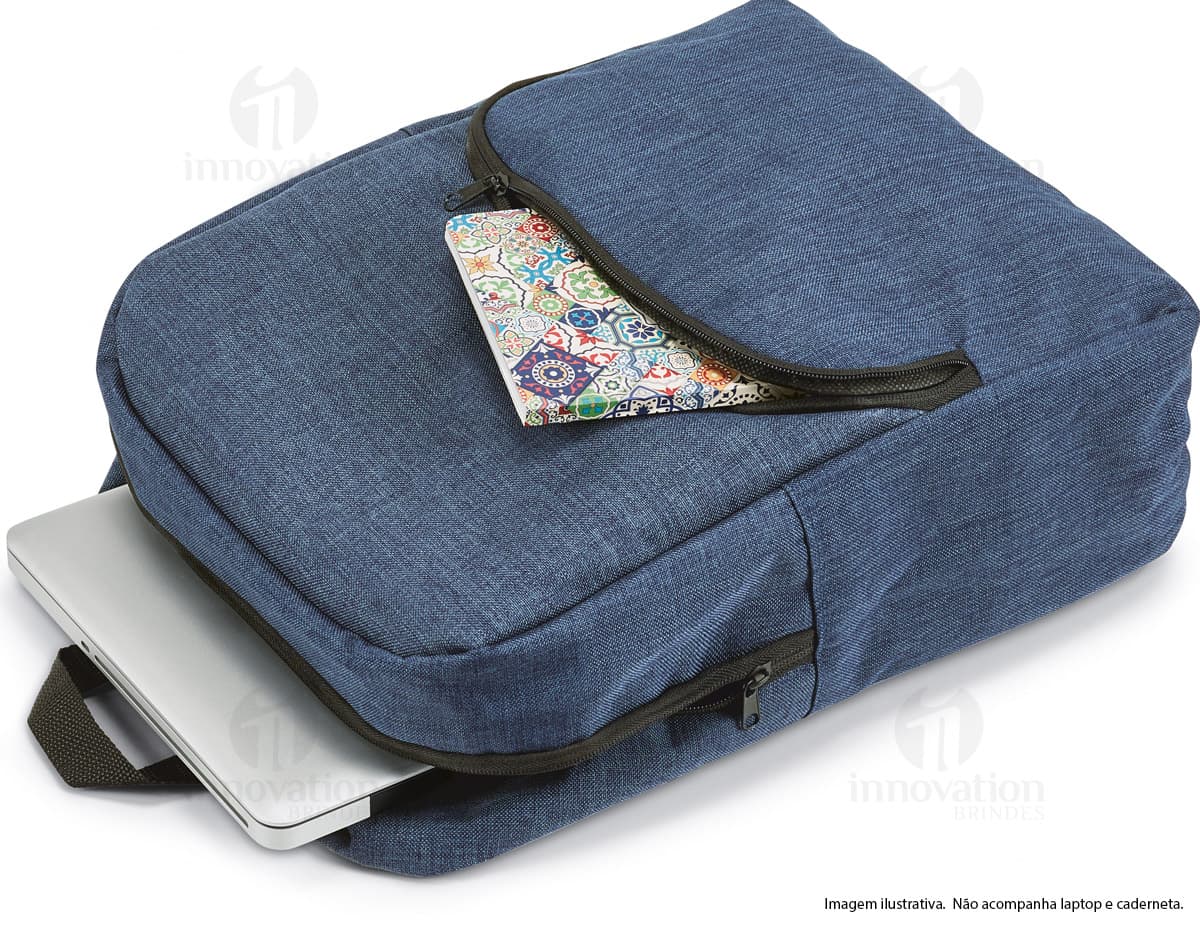 Homem de terno sentado em uma cadeira de escritório preta segurando um telefone em um escritório. Ele está sorrindo e segurando uma mochila azul escuro. Homem de terno sentado em uma cadeira de escritório preta segurando um telefone em um escritório. Ele está sorrindo e segurando uma mochila azul escuro.