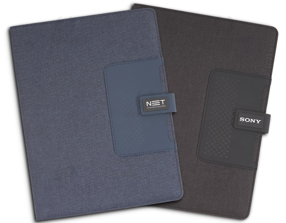 Pasta executiva preta com caderno A4 aberto sobre uma mesa de escritório. Pasta executiva preta com caderno A4 aberto sobre uma mesa de escritório.