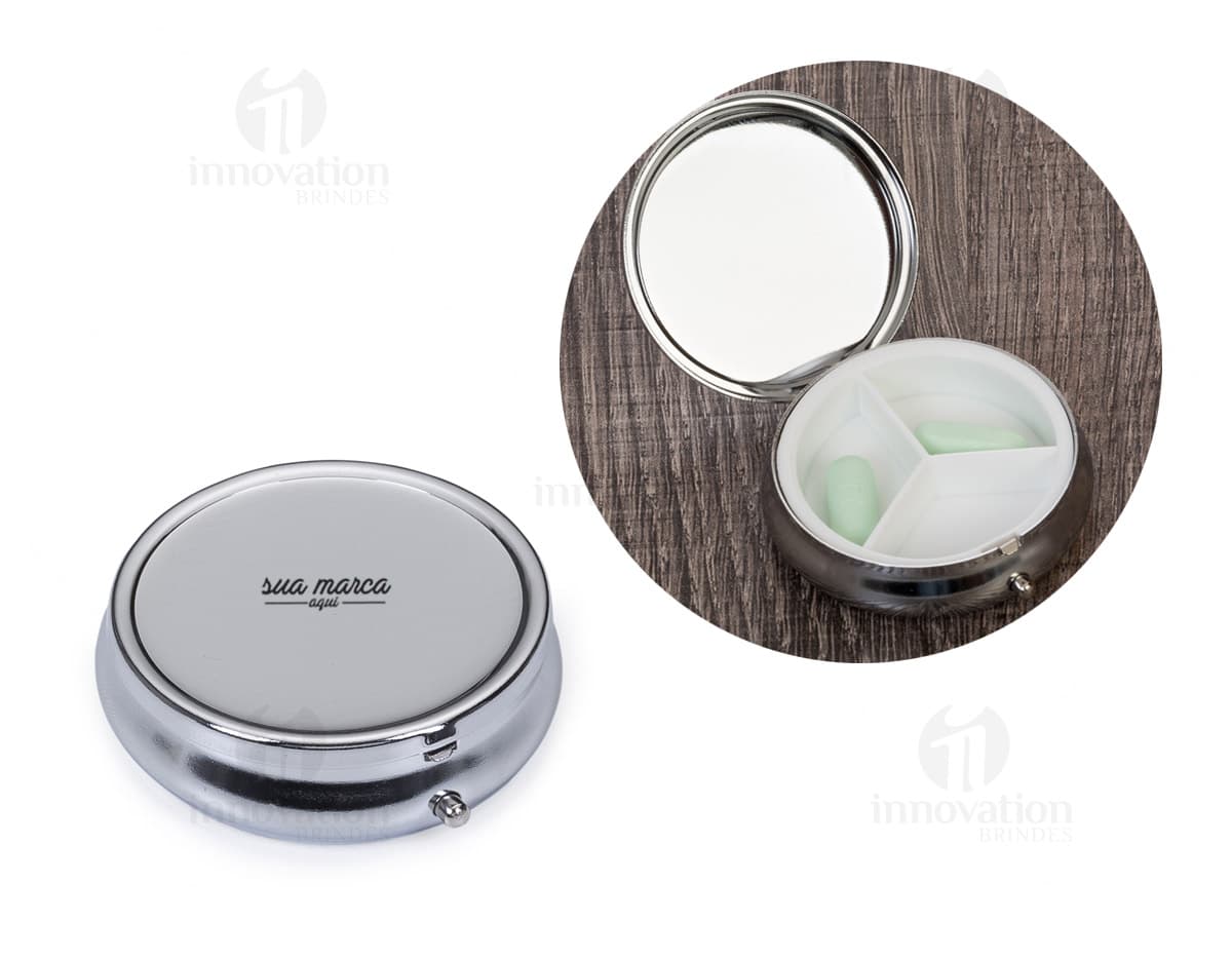 Porta comprimido de metal em formato retangular, na cor prata, com tampa articulada e divisórias internas para organização dos comprimidos. Porta comprimido de metal em formato retangular, na cor prata, com tampa articulada e divisórias internas para organização dos comprimidos.
