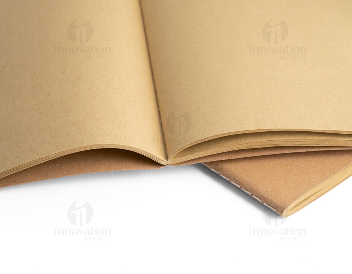 Caderno de couro marrom com capa e caneta prateada ao lado. Caderno de couro marrom com capa e caneta prateada ao lado.