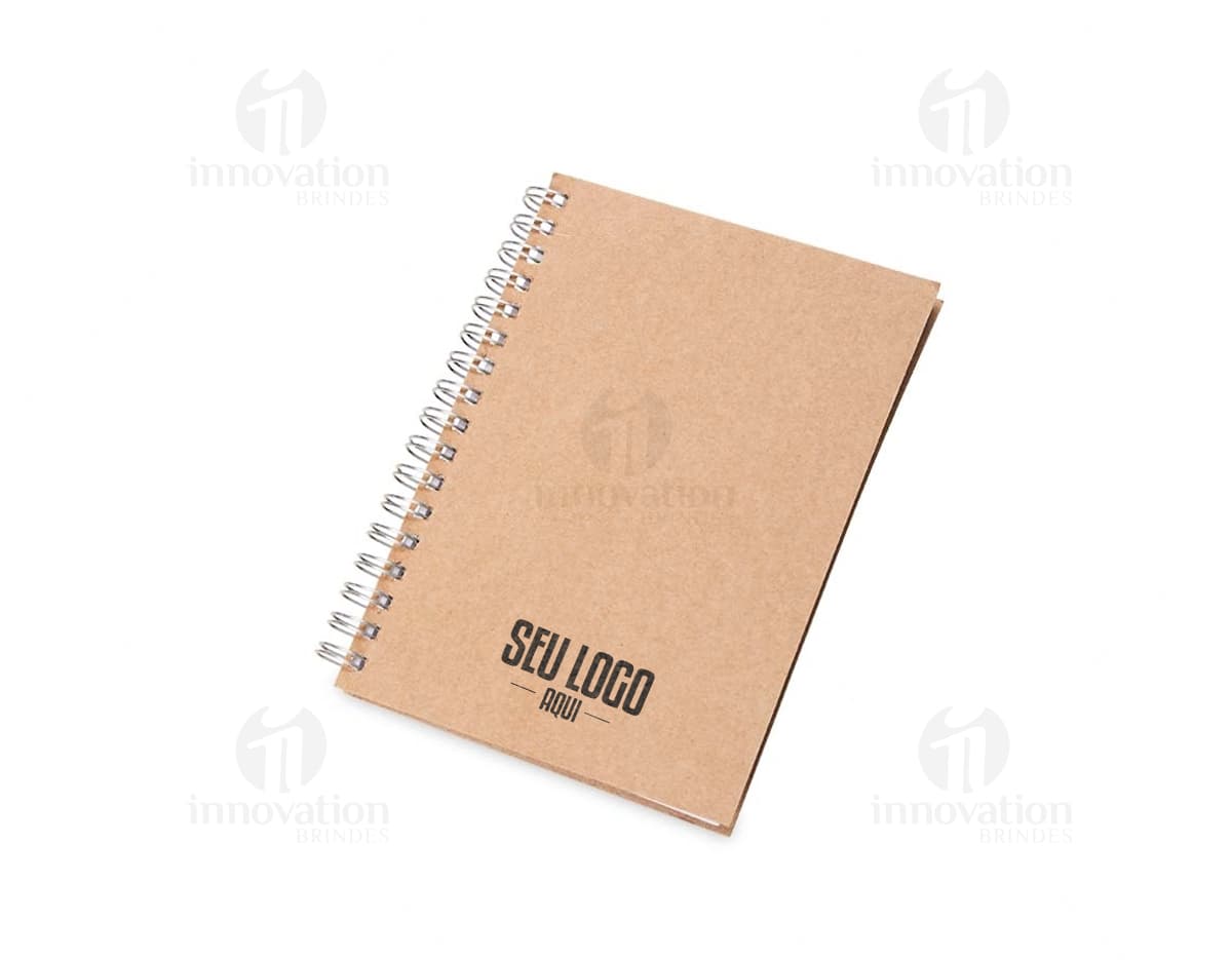 Caderneta ecológica com wire-o em formato horizontal, com capa de papel reciclado marrom claro e espiral metálica. Páginas internas pautadas e caneta esferográfica ao lado. Caderneta ecológica com wire-o em formato horizontal, com capa de papel reciclado marrom claro e espiral metálica. Páginas internas pautadas e caneta esferográfica ao lado.