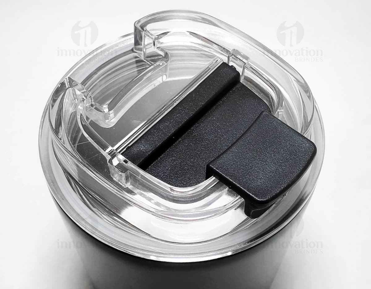 Copo térmico de 280ml em cerâmica preta e metal de cor prateada, com alça e tampa. O copo está vazio e posicionado sobre uma mesa de cozinha, ao lado de uma colher, uma jarra de café e alguns utensílios. Copo térmico de 280ml em cerâmica preta e metal de cor prateada, com alça e tampa. O copo está vazio e posicionado sobre uma mesa de cozinha, ao lado de uma colher, uma jarra de café e alguns utensílios.