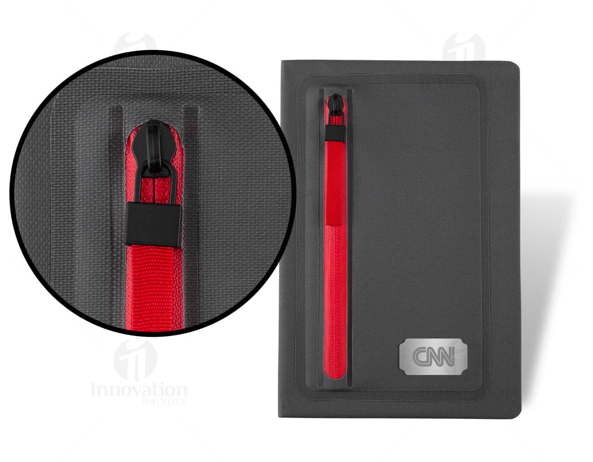Bloco de anotações em linho com capa marrom e elástico de fechamento, apresentando folhas pautadas brancas e um marcador de página em tecido cinza. Bloco de anotações em linho com capa marrom e elástico de fechamento, apresentando folhas pautadas brancas e um marcador de página em tecido cinza.