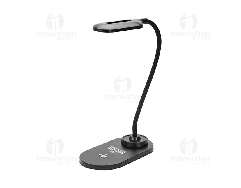 Luminária com carregador em forma de cubo, com base em madeira e detalhes em metal. A luminária tem luz LED e porta USB para carregar dispositivos.